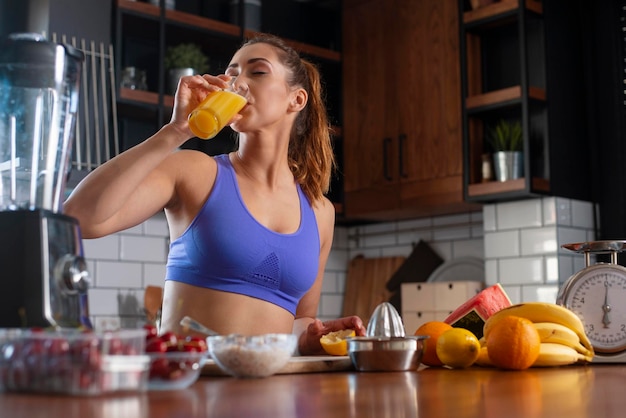 Young woman drinking smoothie and rerlaxing after running