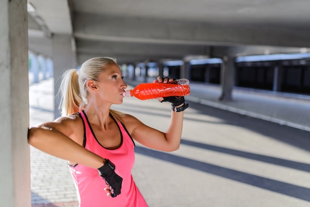 young woman drinking water after r exercise
