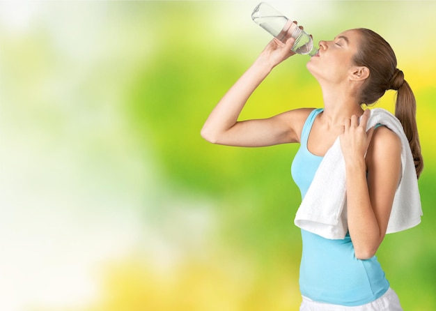 Young woman drinking water after work out