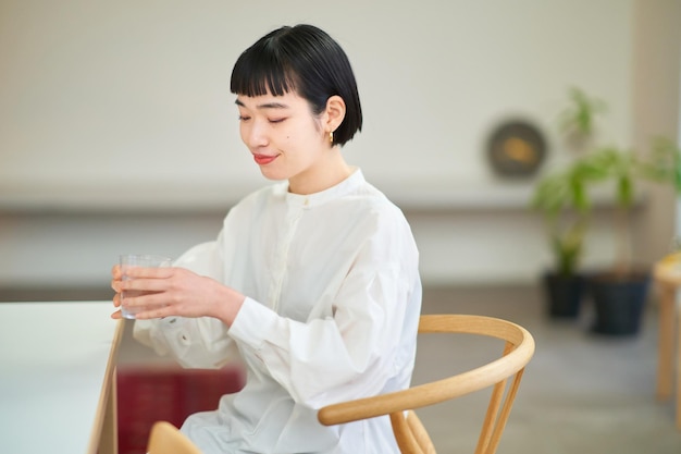 Young woman drinking water in the room