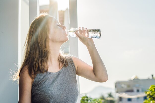 Fitness woman drinking water from bottle. Muscular young female at gym  taking a break from workout. Stock Photo by Satura_