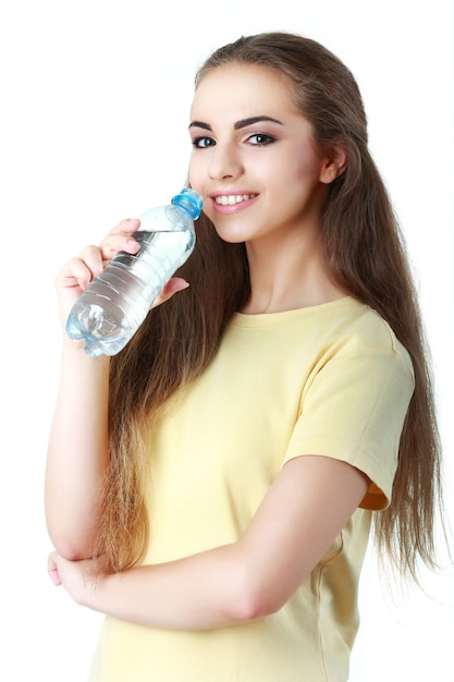 Young woman drinking water on white background