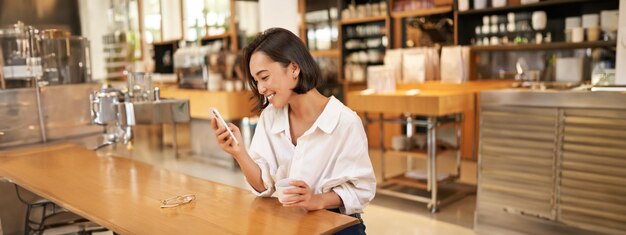 写真 カフェでワインを飲んでいる若い女性