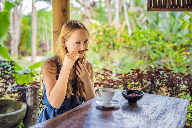 若い女性は望楼でコーヒールアクを飲みます。