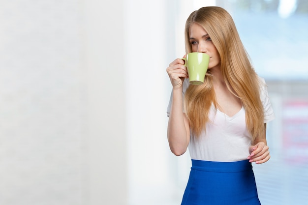 Young woman drinks coffee or tea