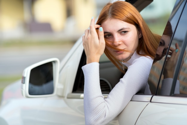 車の窓の外を見て若い女性ドライバー。