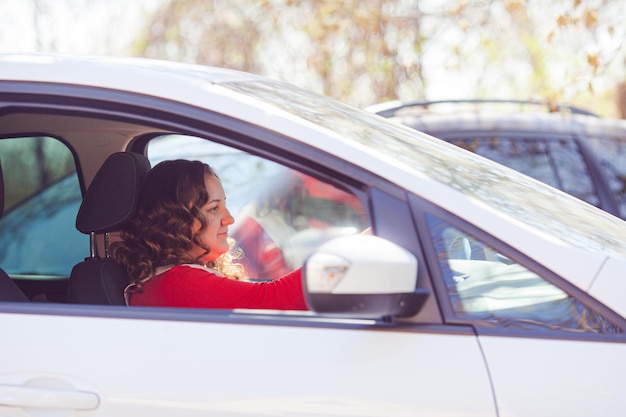 Young woman driving a car on a sunny day ready for departure