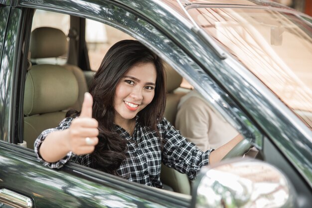 若い女性が彼女の車を運転