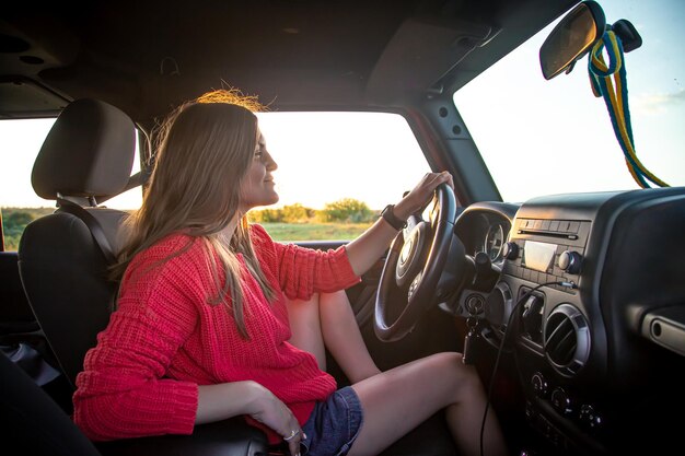 田舎でSUVを運転している若い女性