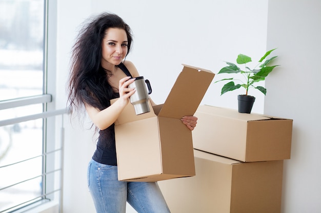 Young woman dropping cardboard box. Moving into new home