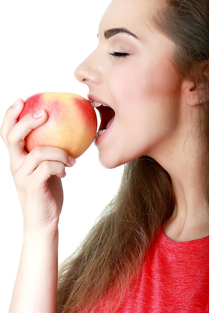 Young woman eating an apple isolated on white