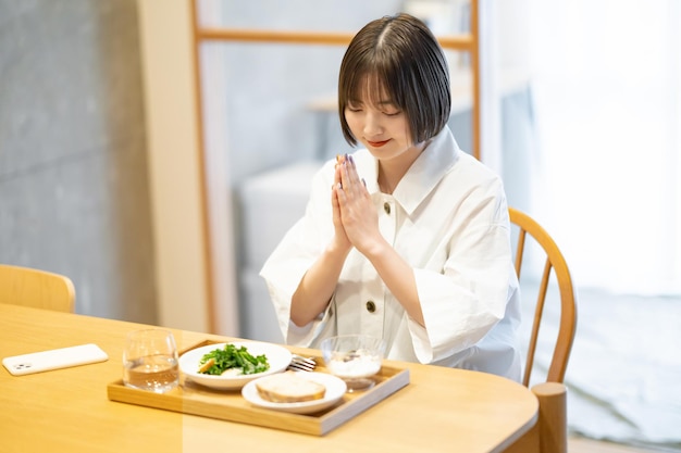 写真 部屋で朝食を食べる若い女性