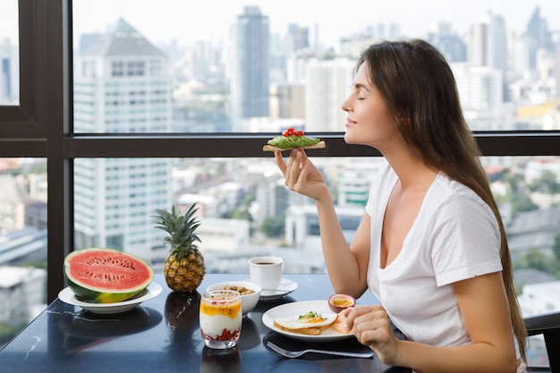 아침에 아침을 먹는 젊은 여자