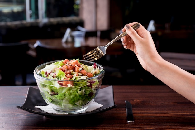 Young woman eating delicious tuna salad in a fancy restaurant, low-calorie nutritious meal - vegetarian