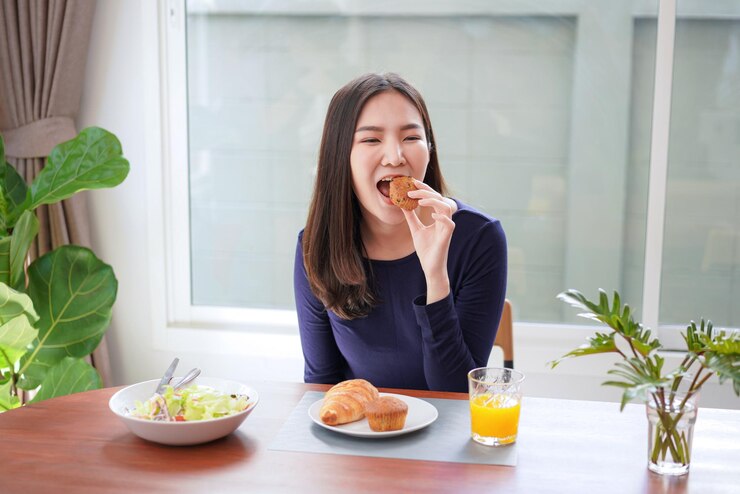 Photo 집에서 음식을 먹는 젊은 여성.