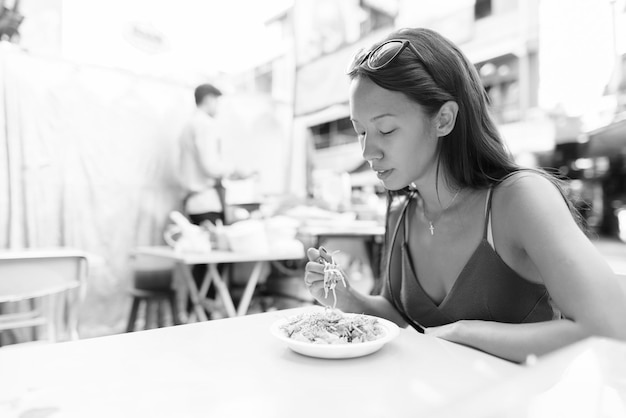 젊은 여성 이 식당 의 테이블 에서 음식 을 먹고 있다