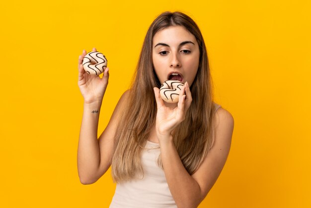 Young woman eating glazed doughnuts