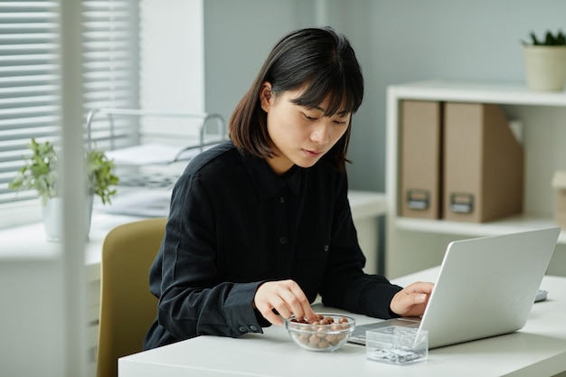 オフィスでおやつを食べる若い女性