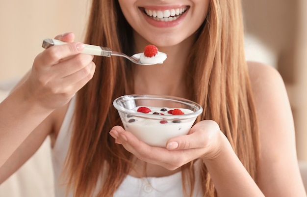 Photo young woman eating yogurt closeup