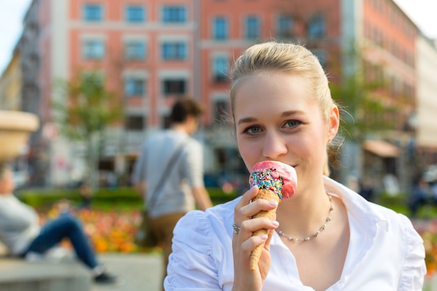 若い女性はアイスクリームを食べる