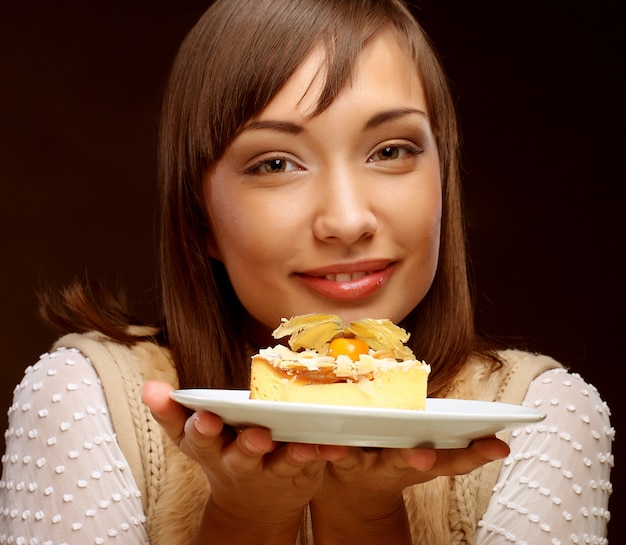 若い女性は甘いケーキを食べる