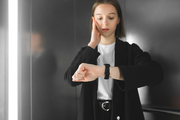 Young woman in the elevator is being late.