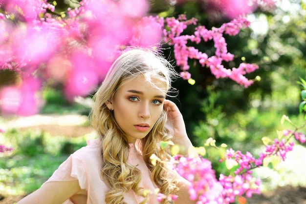 写真 若い女性は庭で花を楽しんでいます。女の子は晴れた春の日に公園を歩きます。