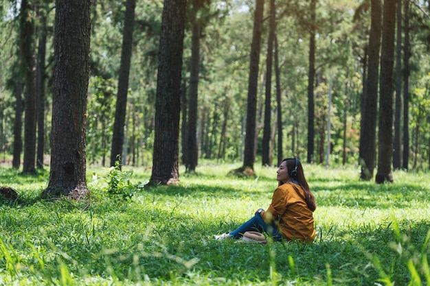 A young woman enjoy listening to music with headphone with feeling happy and relaxed in the park