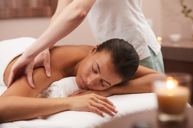 Photo young woman enjoying back massage