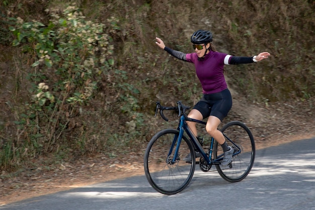 森の真ん中で屋外で自転車に乗るのを楽しんでいる若い女性