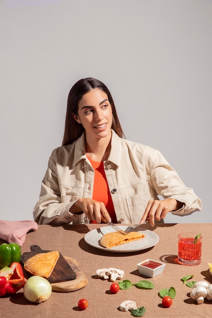 Foto giovane donna che si gode una deliziosa pizza al calzone