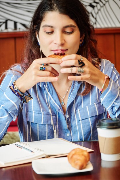 Young woman enjoying delicious pastry