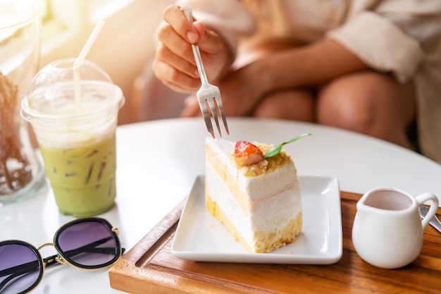 Young woman enjoying eating dessert and drinks in cafe while traveling