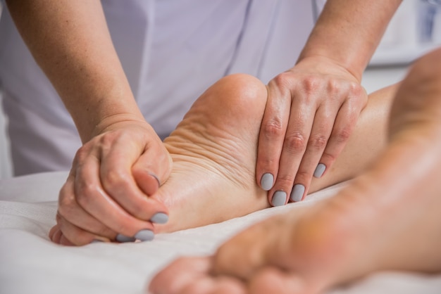 young woman enjoying foot massage in spa salon. Cosmetology