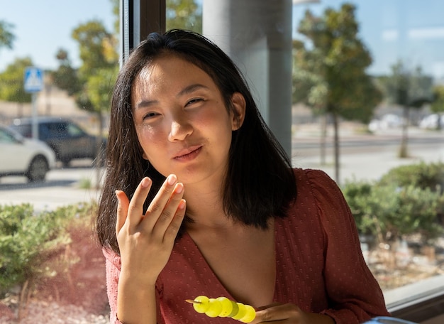 Young woman enjoying her healthy meal, eating grapes, horizontal portrait