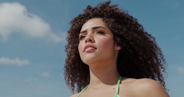 Young woman enjoying her summer vacation on a sunny day smiling and looking at the camera