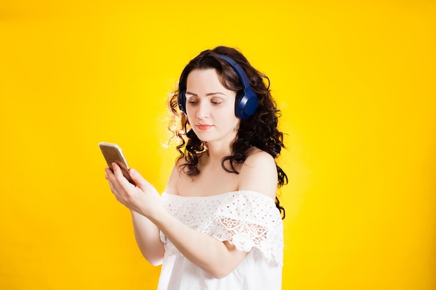 Young woman enjoying life on yellow wall