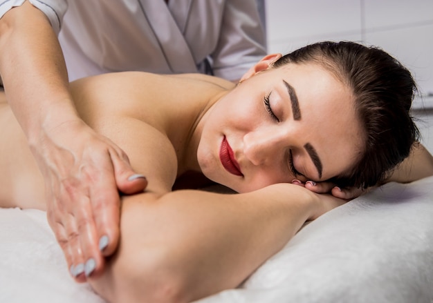 young woman enjoying massage in spa salon. Cosmetology