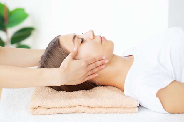 Young woman enjoying massage in spa salon.