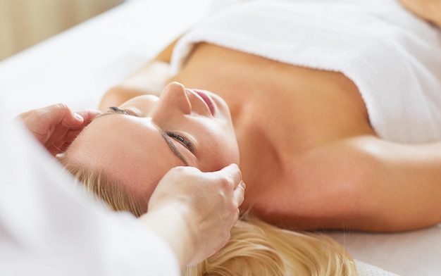 Young woman enjoying massage in spa salon