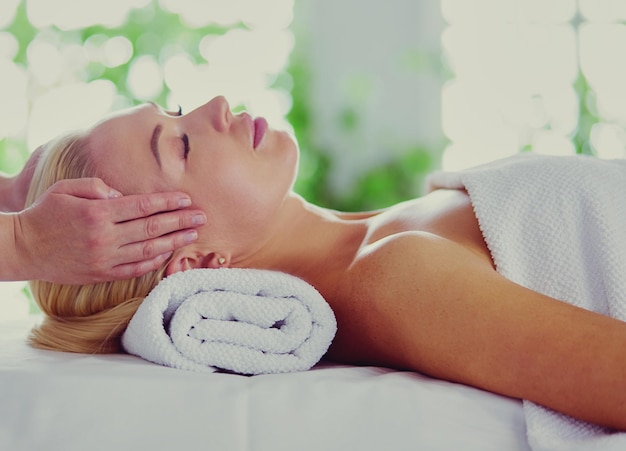 Young woman enjoying massage in spa salon