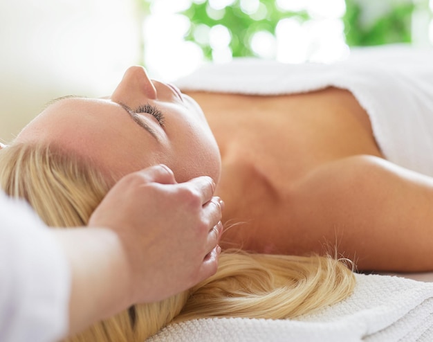 Young woman enjoying massage in spa salon