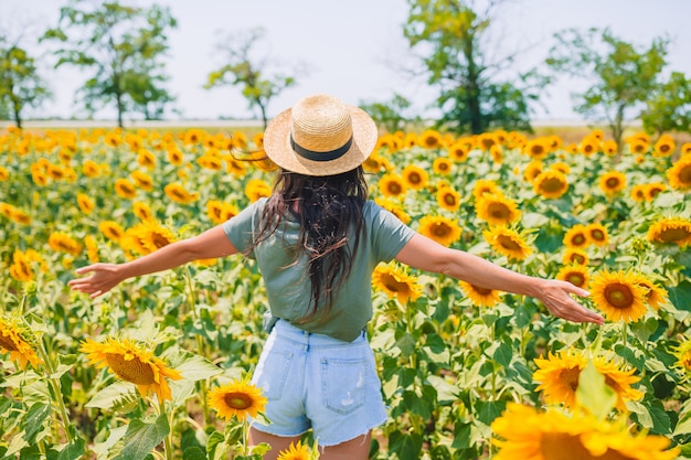 Young woman enjoying nature on the field of sunflowers.