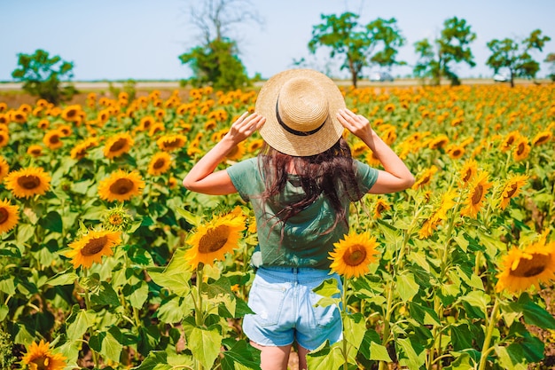 Young woman enjoying nature on the field of sunflowers.