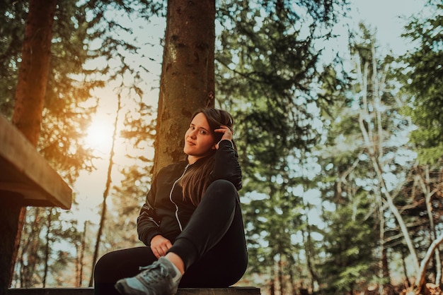 Young woman enjoying nature picnicking in nature walking in the forest enjoying the sunset