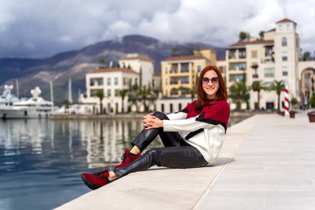 モンテネグロのマリーナ港で海の景色を楽しむ若い女性