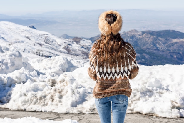 冬の雪山を楽しむ若い女性