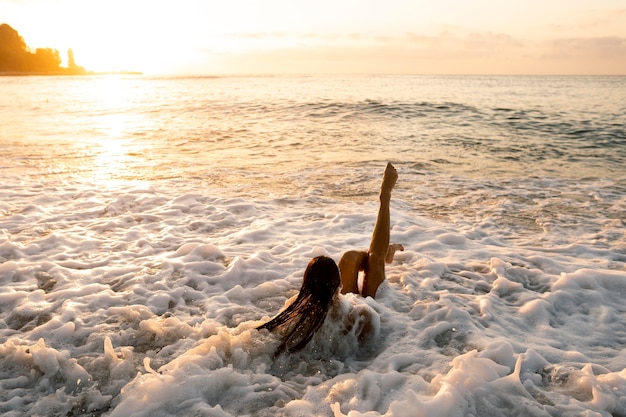 Foto giovane donna che gode del tempo sulla spiaggia