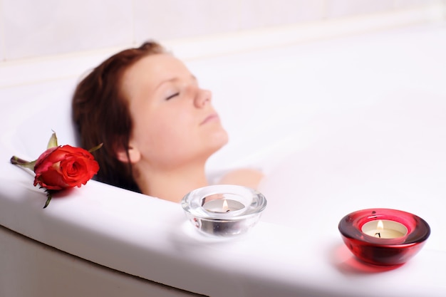 Young woman enjoys the bath-foam in the bathtub. 