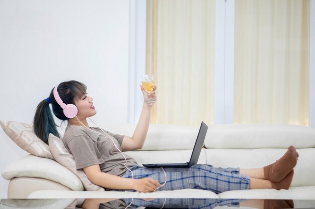 Young woman enjoys champagne on the couch